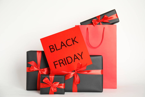 Many gifts and sheet of paper with words Black Friday on white background - Photo, image