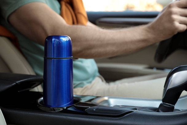 Blue thermos in holder inside of car - 写真・画像
