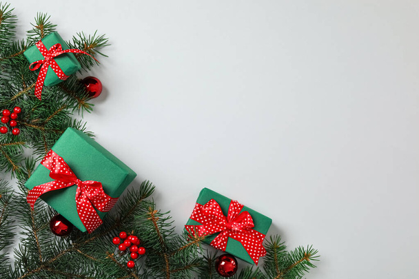 グレーの背景にギフトボックス、クリスマスボールとモミの枝、フラットレイアウト。テキストのスペース - 写真・画像