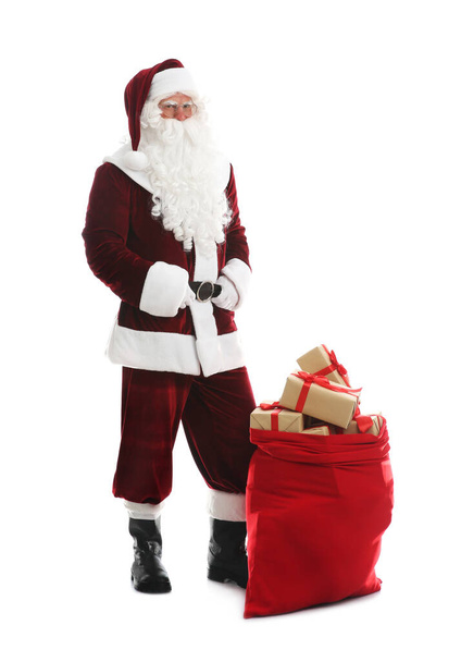 Santa Claus near sack of gifts on white background - Photo, Image