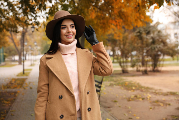 Nuori nainen yllään tyylikäs vaatteita syksyllä puistossa, tilaa tekstiä - Valokuva, kuva