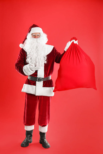 Santa Claus with sack on red background - Fotografie, Obrázek
