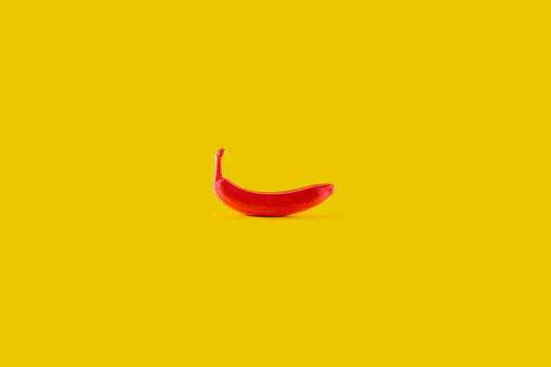 Banano rojo sobre fondo amarillo. Concepto alimentario mínimo - Foto, Imagen