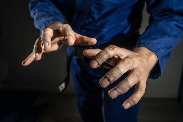 Close up on hands of unknown brazilian jiu jitsu bjj or judo grappler in fighting stance - front view midsection martial arts training concept - Φωτογραφία, εικόνα
