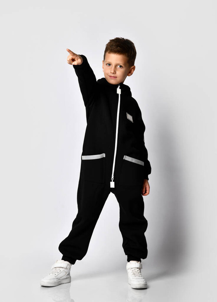 Boy in black warm jumpsuit trendy attire advert - Foto, Bild