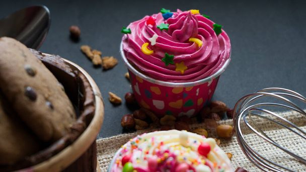 Ritratti dei Cupcake con simpatici coloratissimi minuscoli topping in diverse forme, primi piani su sfondo nero. - Foto, immagini