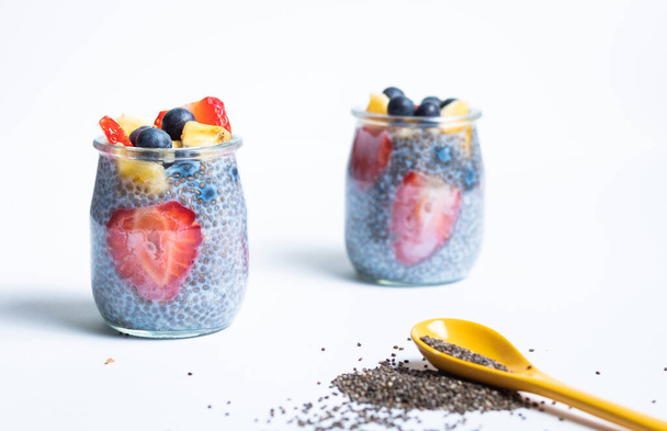 Two glasses of chia isolated with a yellow spoon and chia seeds - Photo, Image