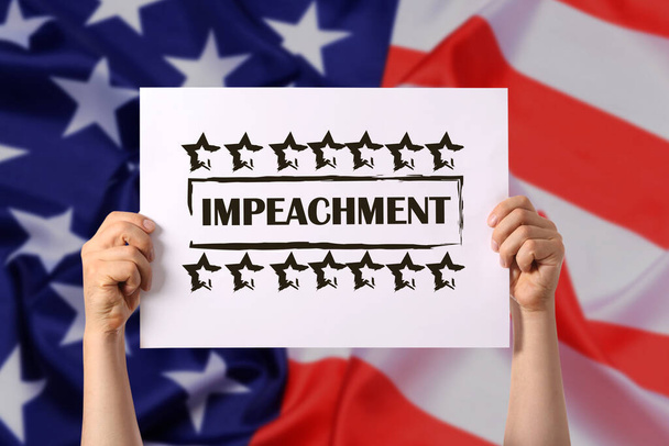 Hands holding paper with word IMPEACHMENT against USA flag - Photo, Image
