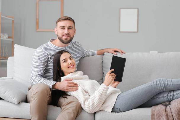 joven pareja leyendo libro en casa - Foto, Imagen