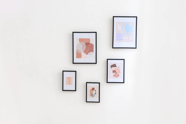 Beautiful pictures hanging on light wall - Fotoğraf, Görsel