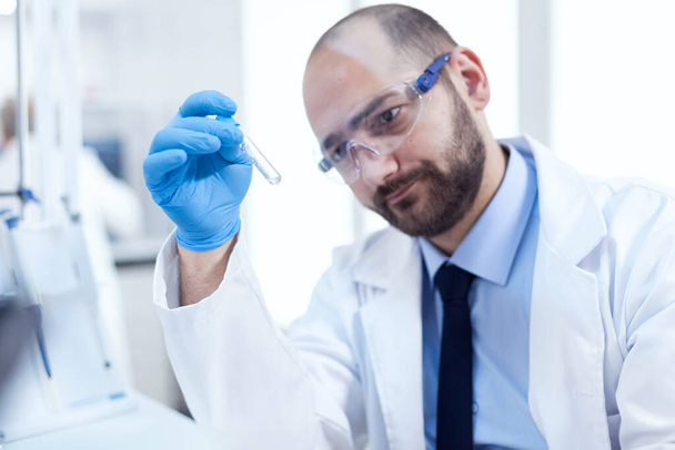 Orvos tudós szakmai laborban keres töprengő a kémcső - Fotó, kép