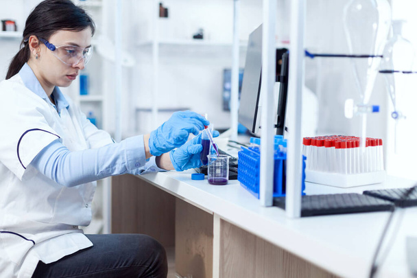 Femme scientifique dans l'industrie de la santé prélevant un échantillon dans une éprouvette - Photo, image