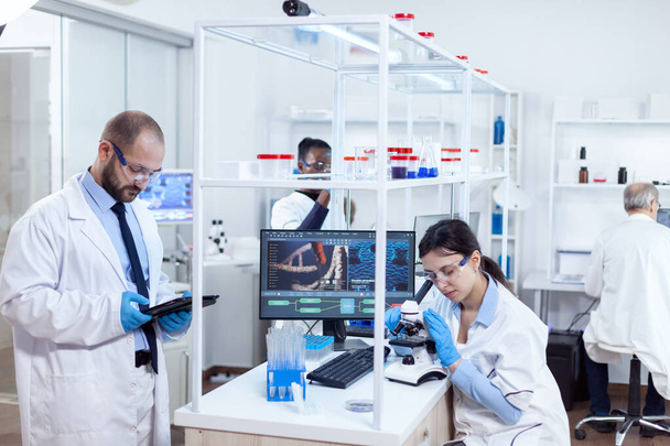 Chemische wetenschappers doen vacine studie in drukke lab - Foto, afbeelding