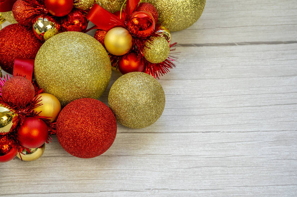 Borda de Natal de ouro e bolas vermelhas em um fundo de madeira branco. Ano Novo cartão espaço cópia. Foto de alta qualidade - Foto, Imagem