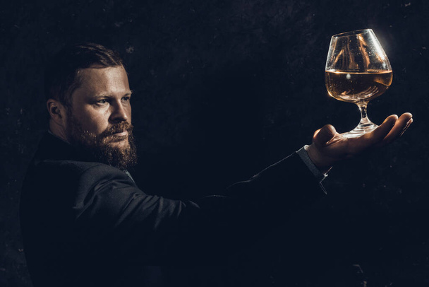 Solid confident bearded man in suit with glass of whisky - Fotografie, Obrázek