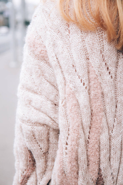 Young beautiful woman in a cozy nude cardigan spends time outdoors. Close up. Without face, noface - Фото, зображення