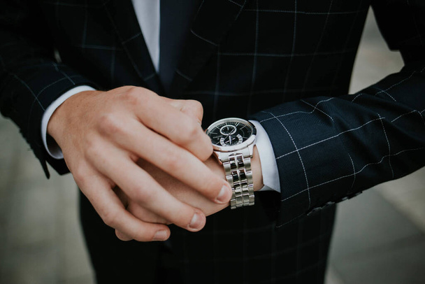 A businessman wearing a suit and checking the time - time management concept - Фото, зображення