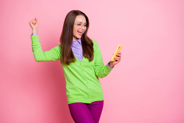 Photo of delighted girl use smartphone win raise fists scream wear shirt pants trousers isolated pastel color background - Φωτογραφία, εικόνα