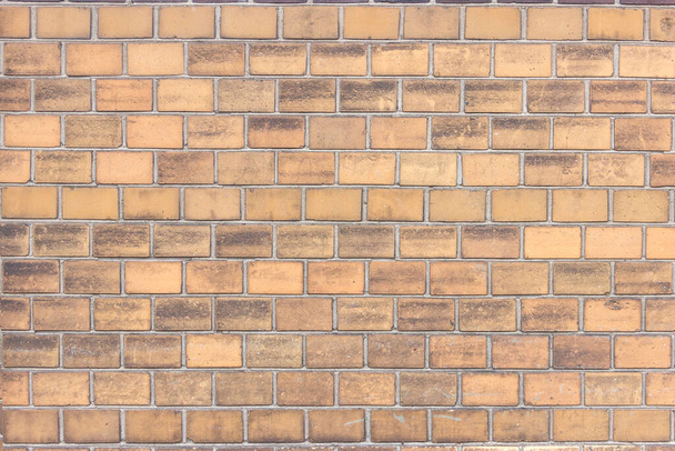 A wall of yellow brick, blackened by the soot of the street and cracked with age. - Фото, изображение