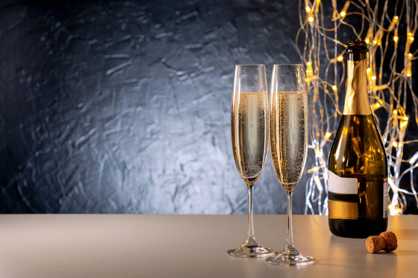 Christmas and New Year holidays background. Glasses of champagne and illumination light. - Zdjęcie, obraz