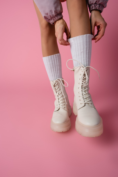 cropped view of female legs in boots and socks on pink background - Fotoğraf, Görsel