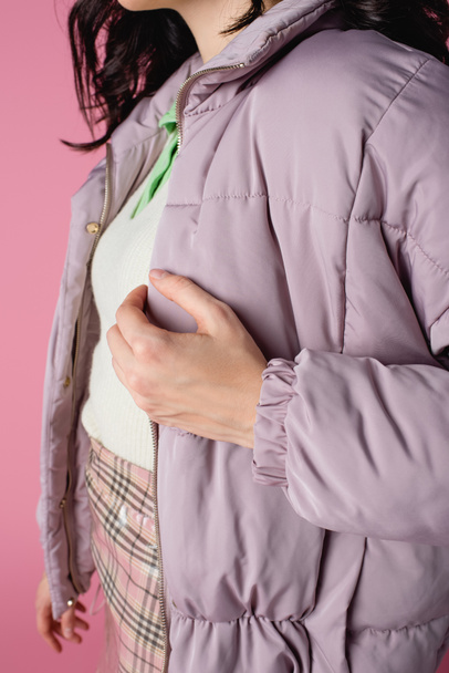 обрезанный вид молодой женщины в стильной куртке фугу на розовом фоне - Фото, изображение