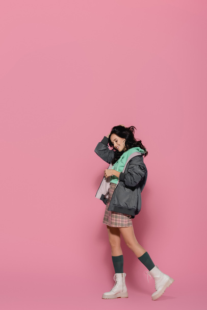 smiling brunette young woman in casual winter outfit posing on pink background - Fotografie, Obrázek