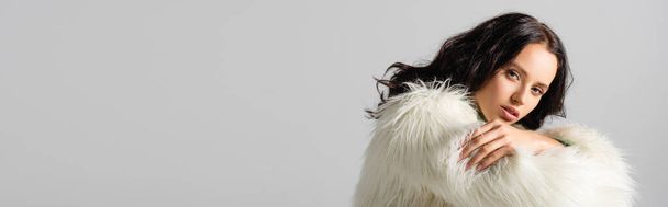 brunette young woman in faux fur jacket posing on white background, banner - Foto, afbeelding