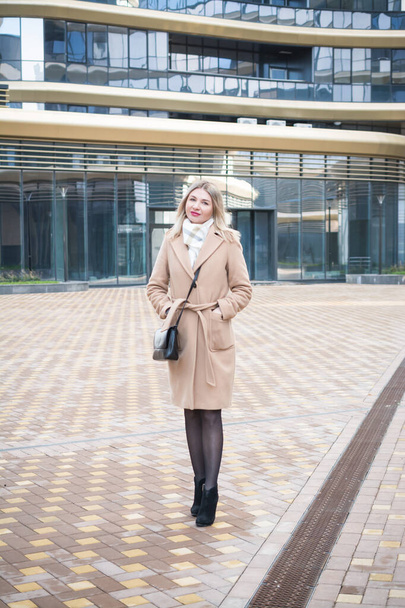 Beautiful blonde business woman in a long autumn coat in the city - Fotó, kép