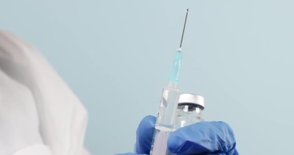 Primer plano de un médico o un profesional sanitario manos que sostienen una vacuna contra el coronavirus, el sarampión o la gripe y una jeringa. Medicina, ciencia y salud - Metraje, vídeo