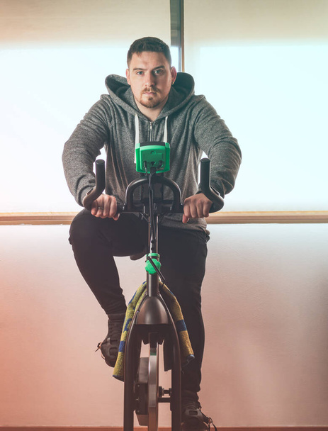 Close up of caucasian man riding on spinning bike - Foto, afbeelding