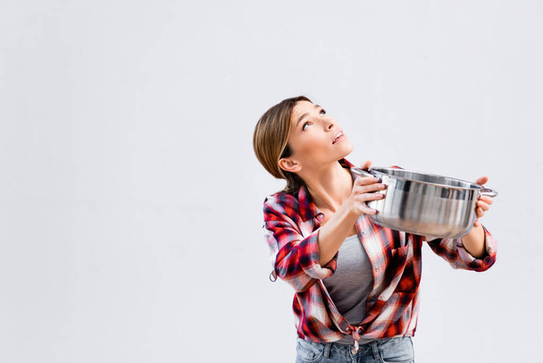 young woman looking up while holding saucepan under leaking ceiling - Photo, Image