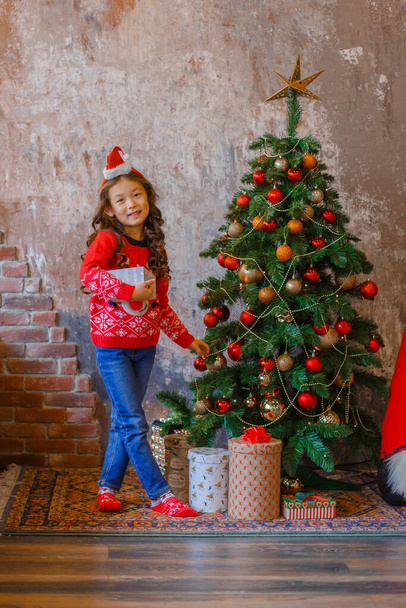 kis ázsiai lány díszíti karácsonyfa mosolygós Karácsony, újév - Fotó, kép