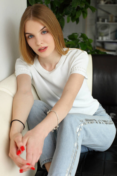 blonde woman sitting on sofa - Fotografie, Obrázek