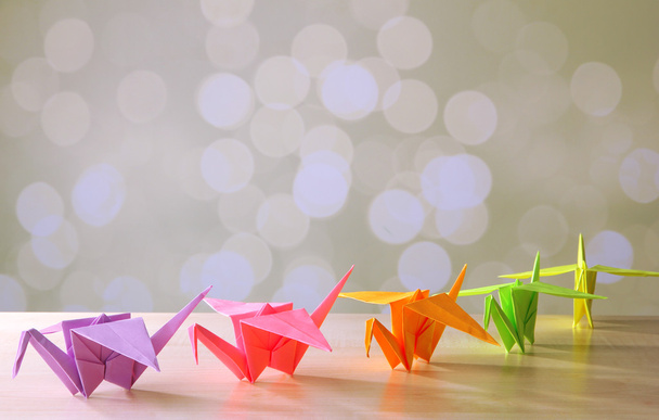 Origami cranes on wooden table, on light background - Fotó, kép