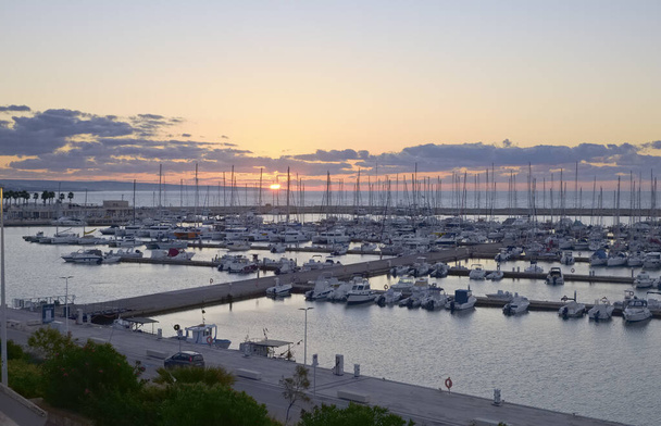 Италия, Сицилия, Средиземное море, Марина-ди-Рагуза (провинция Рагуза); моторные лодки и роскошные яхты в порту на рассвете - Фото, изображение