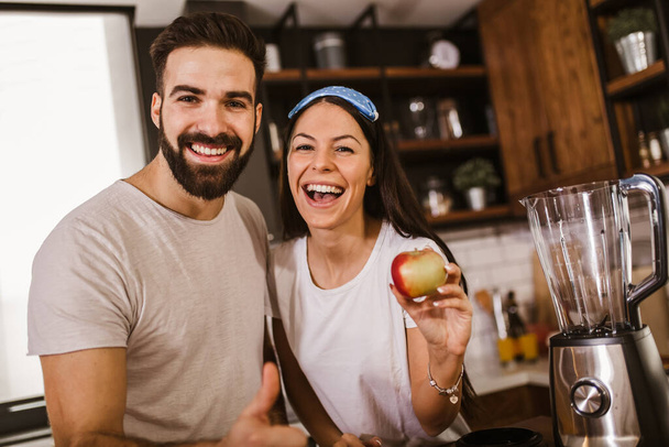 Couple making fresh organic juice in kitchen together - Foto, immagini