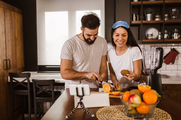 Couple faisant du jus bio frais dans la cuisine ensemble - Photo, image