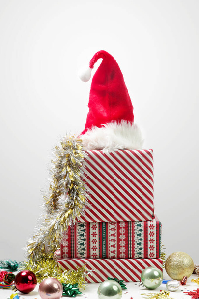 Caixas de presente e chapéu de Papai Noel na mesa com ornamentos de Natal. Férias de inverno divertido e conceito de presentear. - Foto, Imagem