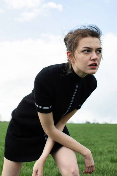 Running girl in black playing sport on green field - Fotografie, Obrázek