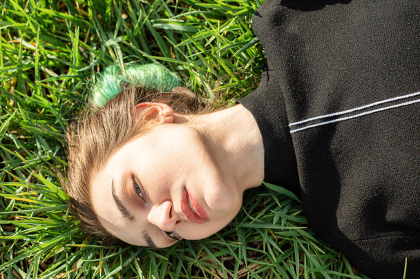 Emotional lying portrait of white girl on green grass - Fotoğraf, Görsel