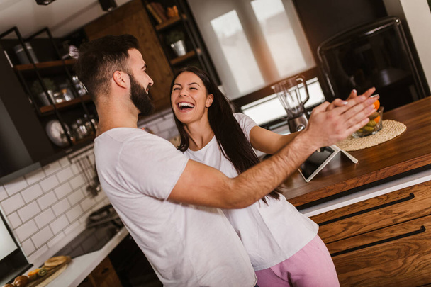 Joyeux couple s'amuser à danser dans la cuisine à la maison le matin - Photo, image