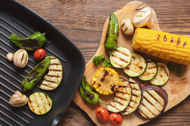 Grilled vegetables in a frying pan and a cutting board. Grill menu, summer snacks, grilled vegetables. Place for text. - Photo, Image