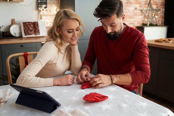 Paar lernt Weihnachts-Servietten falten                                - Foto, Bild