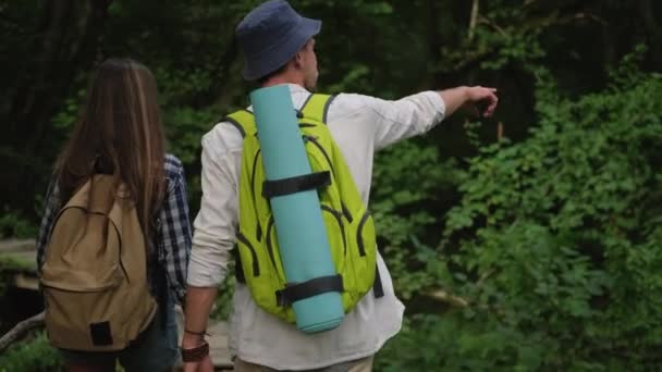 escursionismo e zaino in spalla nella foresta, coppia di uomini e donne stanno camminando - Filmati, video