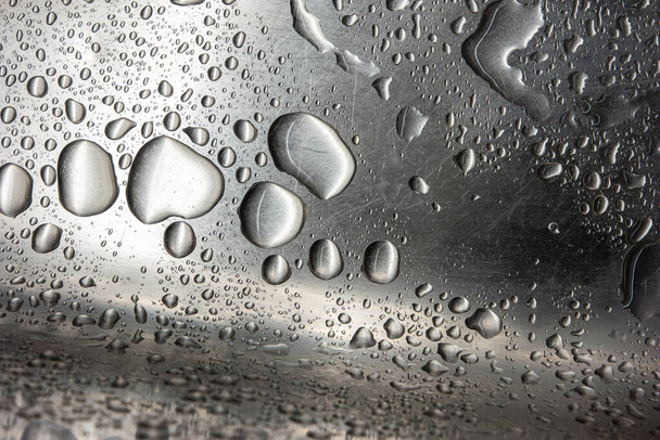 Nerezové kovové kuchyňské dřezy makro zblízka záběr s velkými kapkami vody a poškrábaný povrch textury. - Fotografie, Obrázek
