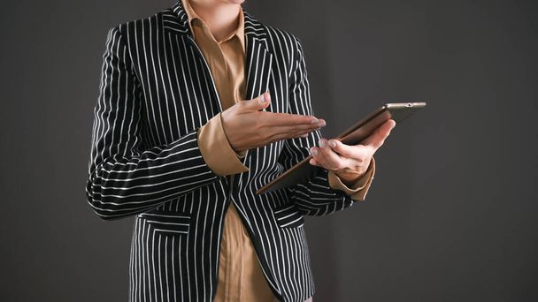 La donna in giacca e cravatta giura su un dispositivo mobile. Foto di alta qualità - Foto, immagini
