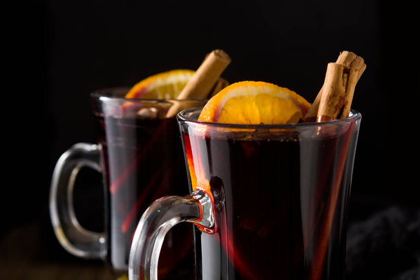 Traditional mulled wine with spices on wooden table - Фото, изображение