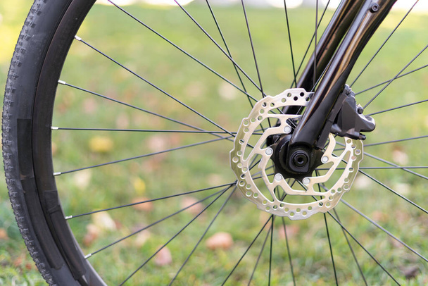 Roue à vélo avec éléments à gros plan : freins à disque, rayons, réflecteur. Contexte sur le thème de Cyclisme, Réparation de vélos, Réglage des freins - Photo, image