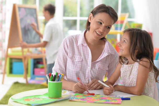 little cute girl with mother drawing  at home - Foto, Imagen